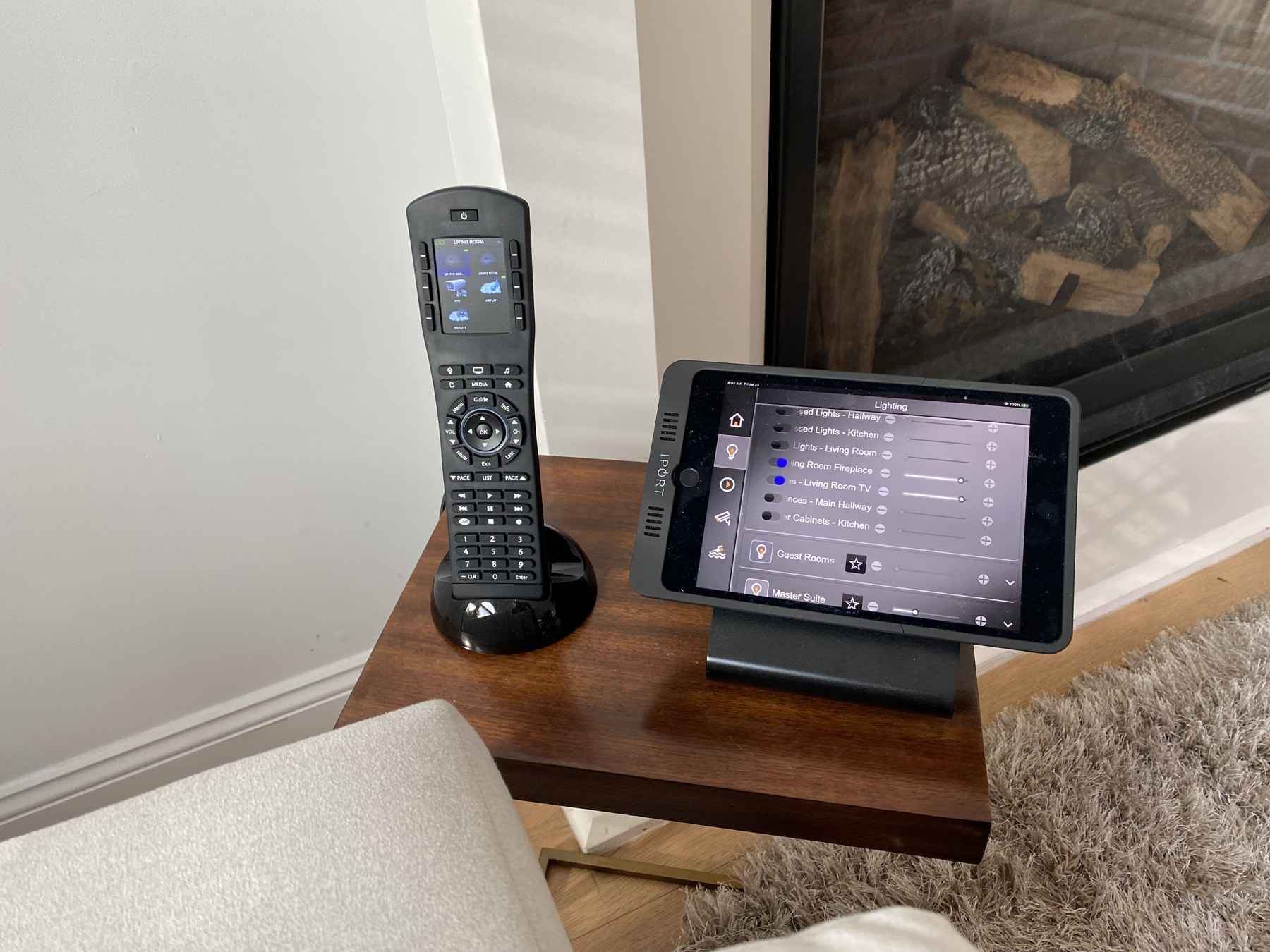 ELAN touchscreen and handheld remote beside living room seating