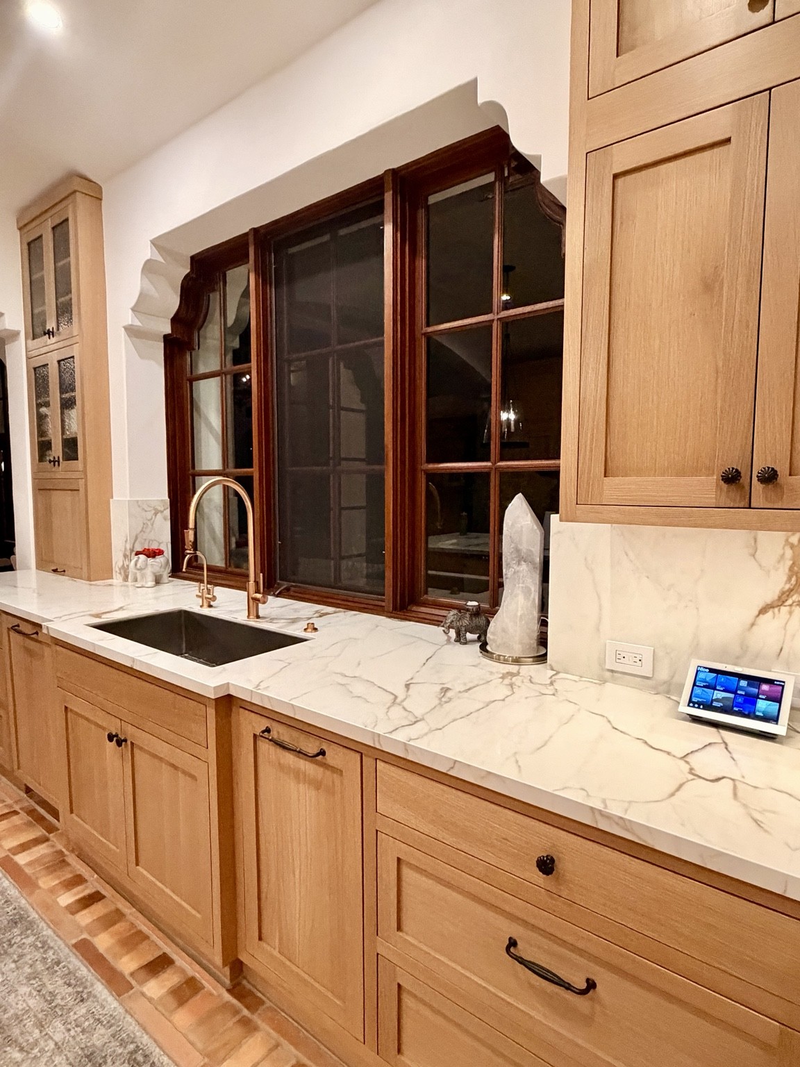 Kitchen countertop touchscreen beside wood cabinetry and marble surfaces