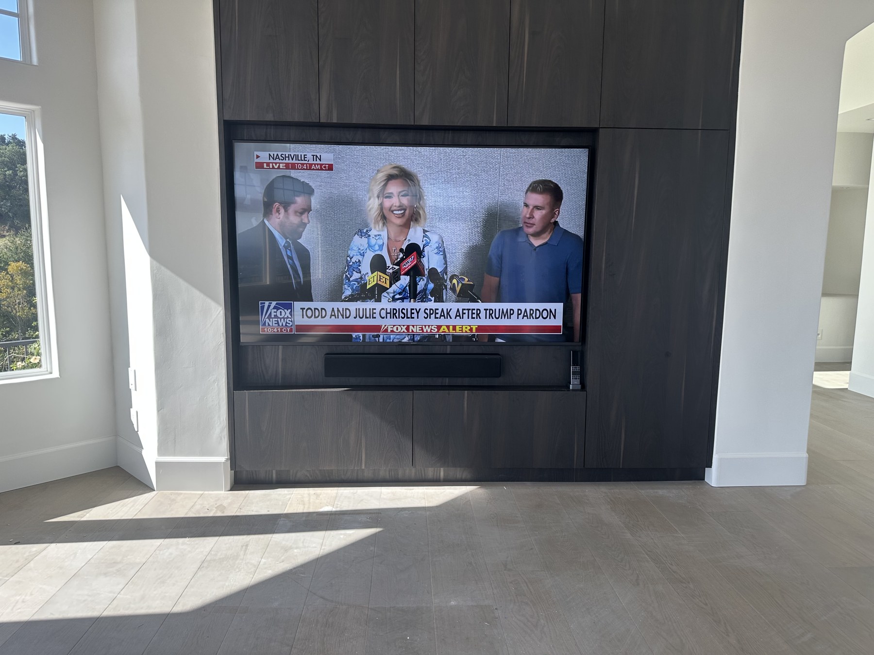 Television integrated into dark wood millwork in the remodeled living space
